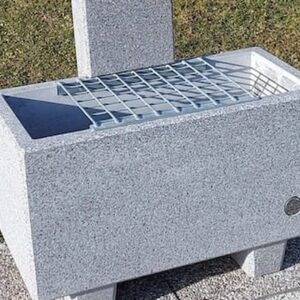 Edelstahl-Gitterrost aufgelegt auf einem Brunnentrog aus Beton