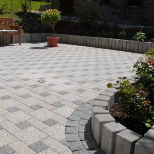 Mini-Palisade grau als Beeteinfassung neben gepflasterter Terrasse